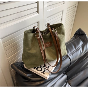 Detail of dark green tote bag featuring heart embossed pattern and magnetic closure