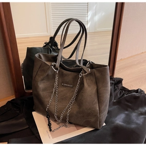 Detail view of large matte tote bag with silver chain decor and MUDNSHARK logo
