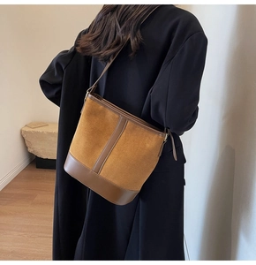 Detailed back view of a vintage brown suede bucket bag worn by a model in soft light