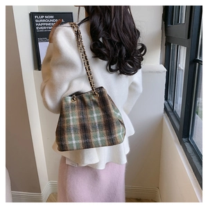 Detail of vintage plaid wool shoulder bag with green and brown patterns and chain straps