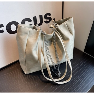 Detail of minimalist tote bag with matte faux leather texture and silver chain strap