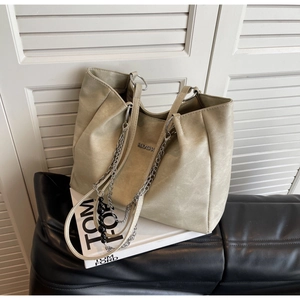 Detail of light green tote bag with matte PU leather finish and thick metal chain decoration