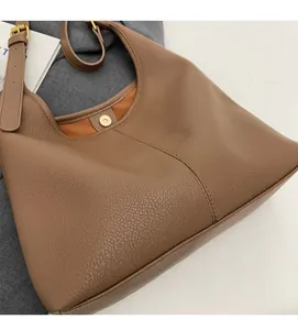 Detail view of large brown lychee leather bucket bag with golden magnetic snap closure