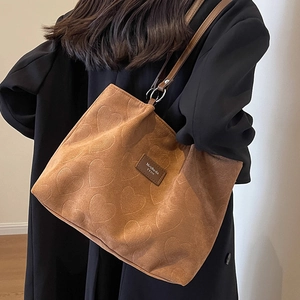 Brown textured tote bag with embossed hearts and adjustable shoulder strap for autumn style