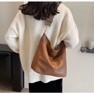 Detailed view of large brown hobo bag with bohemian geometric woven strap on model