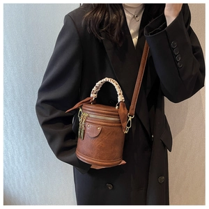 Détail du sac cylindre marron vintage avec poignée en foulard léopard et bandoulière