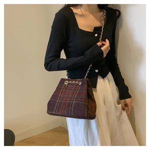 Détail du sac seau écossais avec chaîne dorée et motif à carreaux violets vintage