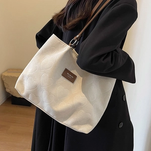 Off-white large tote bag with embossed heart pattern and brown leather straps