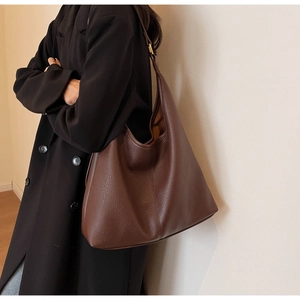 Deep brown large-capacity hobo bag made of lychee grain leather, stylishly carried by model