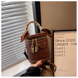 Vue détaillée du sac seau marron avec foulard léopard enroulé sur la poignée