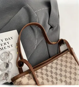 Detail of vintage monogram tote bag featuring brown leather handles and gold metal rivets