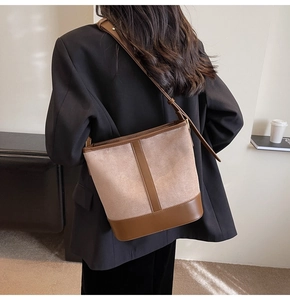 Detail of vintage brown bucket bag showing mixed suede and leather textures and strap