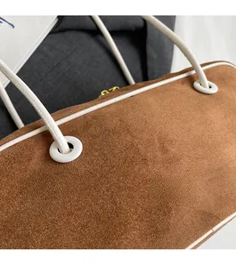 Gros plan d'un sac à main en daim caramel avec texture mate et bordures blanches