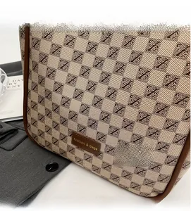 Close-up of beige and brown monogram tote bag with leather tag and premium fabric texture