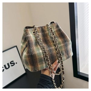 Detail of multi-color plaid tweed bucket bag with gold chain strap and soft texture