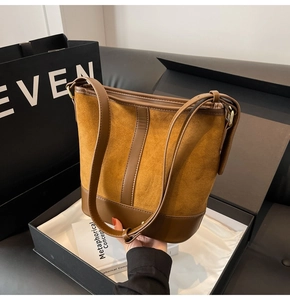 Detailed view of large patchwork suede bucket bag with leather straps and gold hardware