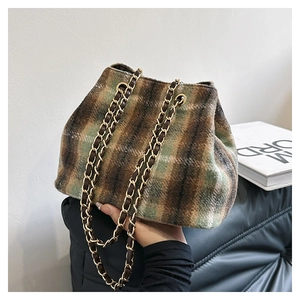 Gros plan du sac seau en laine à carreaux vintage avec bandoulière en chaîne dorée