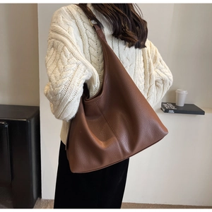 Brown lychee texture hobo bag worn by model showing large capacity and drape