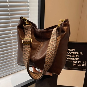 Large dark brown leather tote bag with vintage woven shoulder strap and spacious hobo design