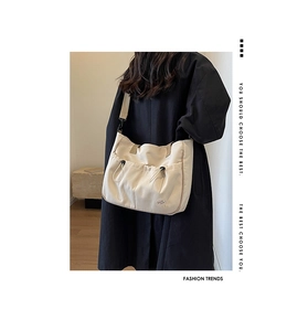 Detail der Canvas-Tasche mit Kordelzugtasche und 'Good luck!'-Label sowie schwarzem Gurtband