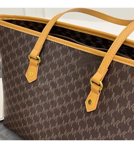 Detail of classic brown monogram tote bag with yellow trim and gold metal rivets