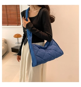 Sac à bandoulière matelassé bleu avec rembourrage doux présenté sur un mannequin de mode