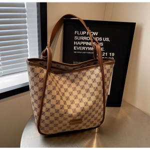 Detail showing the large-capacity tote bag with retro monogram pattern and leather straps