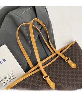 Macro detail of brown monogram tote bag with leather straps and gold metal hardware