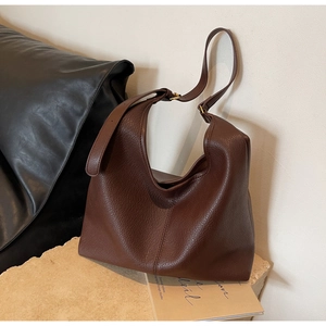 Close-up of dark brown hobo bag with pebble texture leather and vintage gold hardware