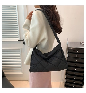 Gros plan d'un grand sac hobo matelassé noir avec une texture de surpiqûres en losanges