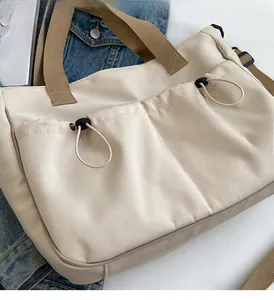 Detailaufnahme der beigen Canvas-Einkaufstasche mit Kordelzugtaschen und braunen Griffen