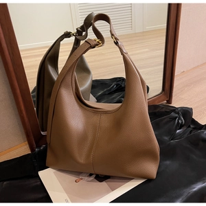 Close-up of dark brown lychee leather hobo bag with adjustable strap and gold hardware