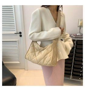 Sac matelassé beige en nylon avec grand motif losanges porté par un mannequin