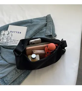 Top view of spacious nylon crossbody bag holding umbrella, wallet, and water bottle