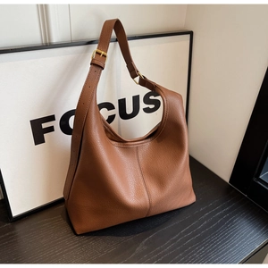 Detailed view of brown litchi grain leather texture and adjustable golden strap buckle