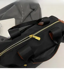 Detail of smooth gold zipper hardware and durable nylon texture on black pillow bag