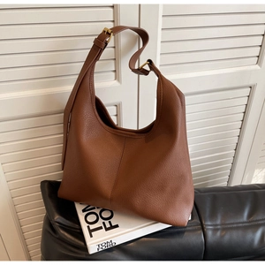 Detail of brown litchi pattern leather hobo bag with adjustable gold buckle strap