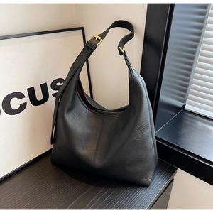 Close-up of black lychee grain hobo bag featuring adjustable strap and gold metal buckle