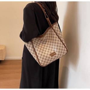 Detail of the check pattern tote bag with brown leather trim and golden rivets