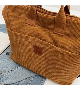 Detail of caramel corduroy tote bag showing soft ribbed texture and front pocket