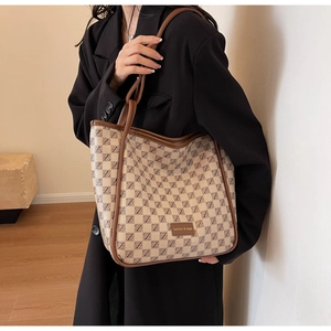 Large checkered tote bag with Z-letter pattern and brown leather handles shown on model