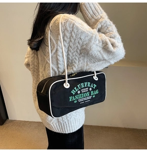 Détail du sac bowling rétro en toile noire avec passepoil blanc et texte du logo