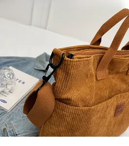 Detail view of corduroy tote bag with sturdy metal hooks and durable shoulder straps