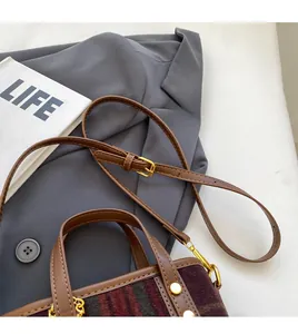 Détail de la bandoulière réglable et boucle dorée sur le sac seau en laine écossaise