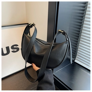 Détail de la texture cuir grainé et de la boucle dorée sur le sac demi-lune noir