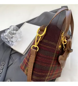 Détail d'un sac seau en tweed à carreaux multicolores avec garniture en cuir brun