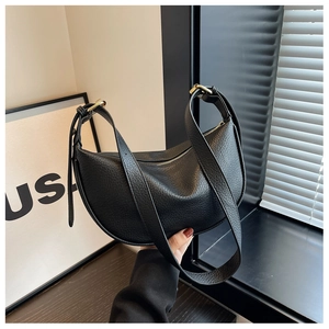 Détail du sac hobo en cuir grainé noir avec boucle dorée ajustable et fermeture éclair