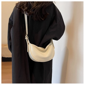 Détail de la texture litchi blanc crème et de la bandoulière réglable du sac demi-lune