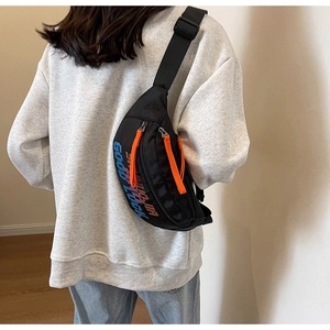 Detail van de zwarte crossbodytas met brede verstelbare nylon riem op een model getoond