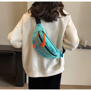 Detail van turquoise nylon crossbodytas met oranje trekkoorden en zwarte schouderband